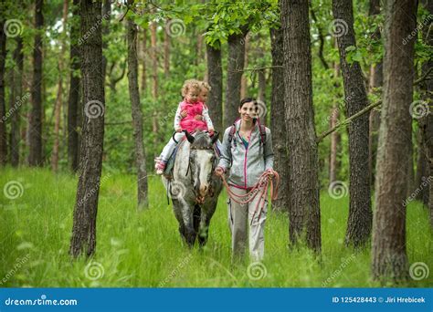 Girls Enjoying Horseback Riding In The Woods With Mother Young Pretty