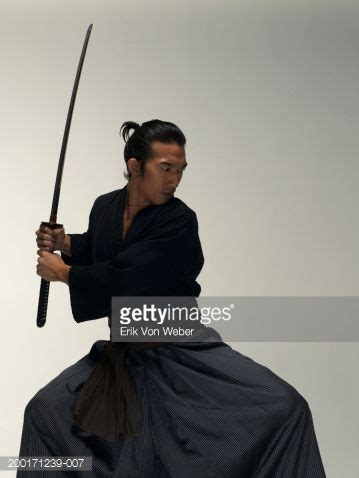 Man holding sword in fighting position – Artofit