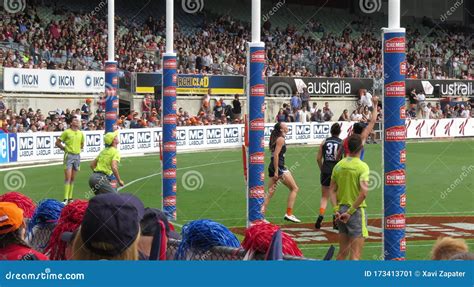 Players and Umpire Looking the Footy Crossing the Goal Posts Line in ...