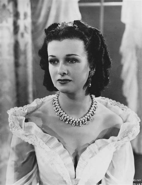 An Old Black And White Photo Of A Woman In A Dress With Pearls On Her Neck