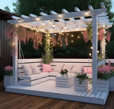 An Outdoor Seating Area Is Lit Up With String Lights And Pink Flowers