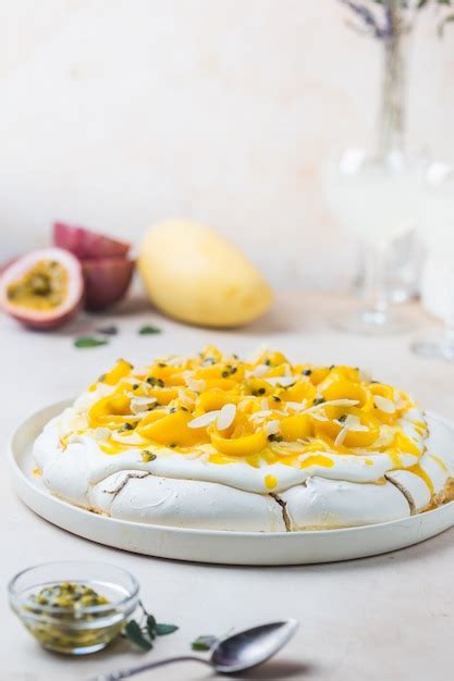 Pastel de merengue pavlova con mango fresco y maracuyá y crema batida