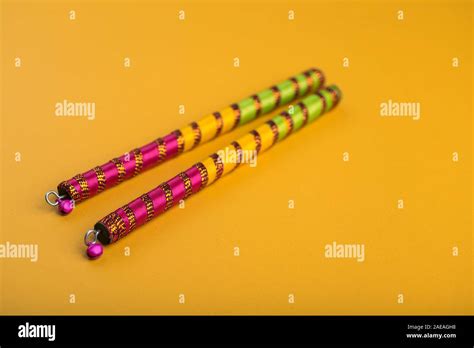 Dandiya sticks on a yellow background. Raas Garba or Dandiya Raas is ...