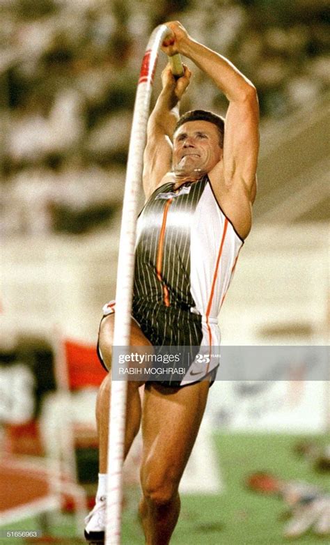 A Man Jumping High In The Air With A Pole On His Feet And One Hand Up