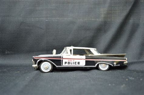 A Toy Police Car Sitting On Top Of A Black Surface