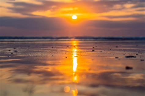 Puesta De Sol En La Playa De Kuta Con Reflejo En El Agua En La Isla De