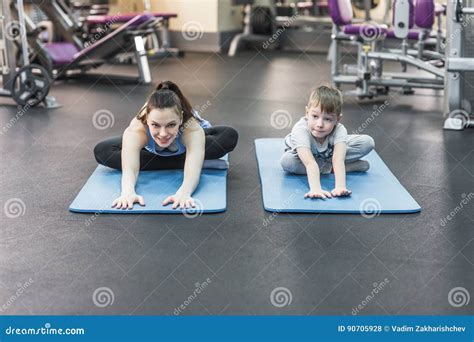 Madre Con El Hijo Que Hace Estirar En El Gimnasio Foto De Archivo