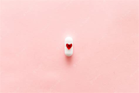 Premium Photo One White Pills On Pink Background With Red Heart Shape