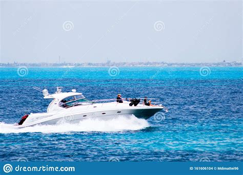 White Boat Creating Waves And Crashing Into The Clear Blue Water