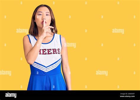 Young Beautiful Chinese Girl Wearing Cheerleader Uniform Asking To Be