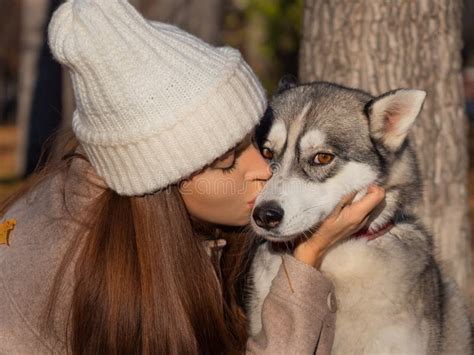 A Young Woman Hugs And Kisses Her Dog A Husky Stock Photo Image Of