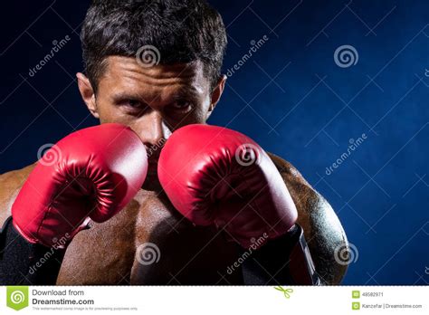 Boxeador Muscular Fuerte En Guantes De Boxeo Rojos En Un Fondo Azul