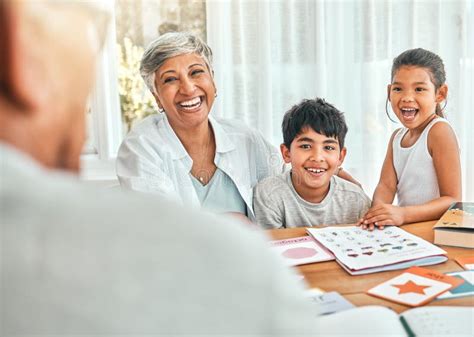 Happy Homework And Grandmother Sitting With Her Grandchildren Helping