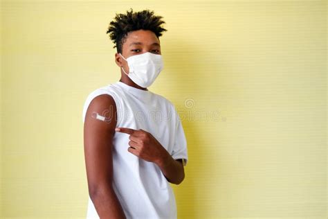 Portrait African American Man Wearing Face Mask And Showing Arm With Bandage After Getting