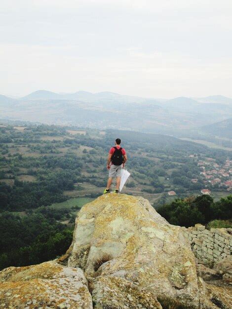 Premium Photo Rear View Of Man Standing On Cliff Against Sky