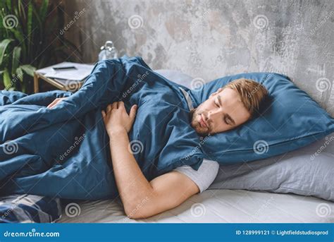 Young Handsome Man Sleeping Under Blanket In His Bed Stock Image