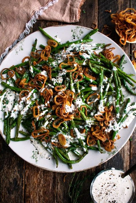 A White Plate Topped With Green Beans And Onions