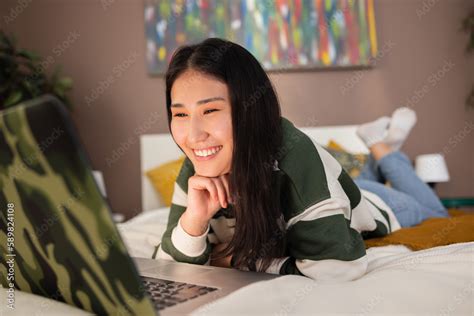 Happy Asian Kazachstan Middle Aged Young Girl Woman Laying In Bed Smiling Wearing Casual New