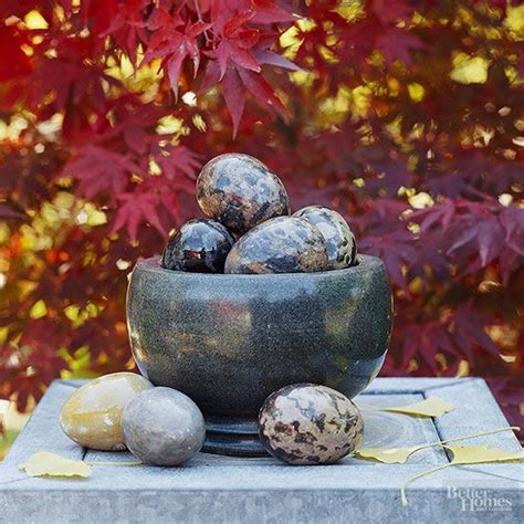 A Bowl Filled With Fruit Sitting On Top Of A Cement Table Next To