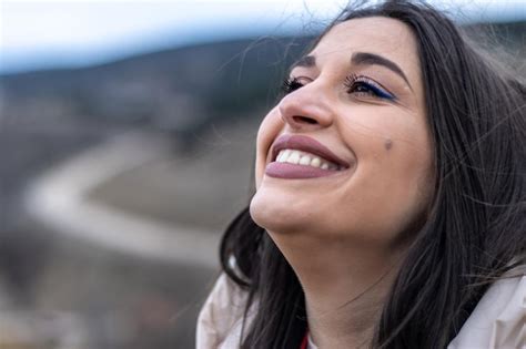 Cerca De Una Mujer Sonriendo Y Mirando El Cielo En La Naturaleza Foto