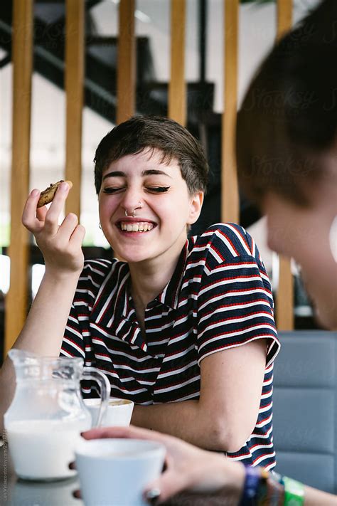 Girl With Piercings Laughing On The Table With Coffee Del