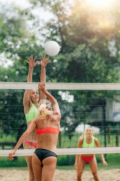 Premium Photo | Female team playing beach volleyball