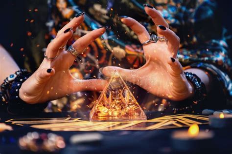 A Witch Conjures A Magic Glass Pyramid Hands Close Up Sparks Flare Up