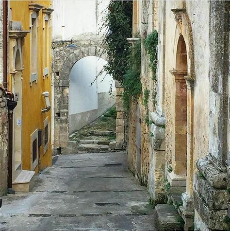 An Alley Way With Stone Buildings And Vines Growing On The Walls