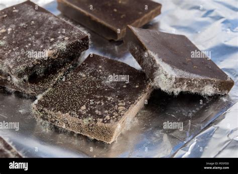 Moldy chocolate in the original packaging. Out-dated food products used for desserts. White ...