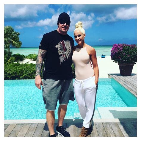 a man and woman standing next to each other in front of a pool