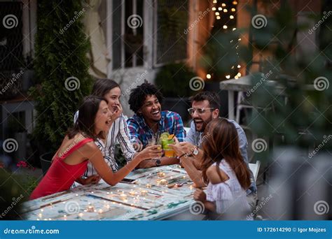 Group Of Five Adults Making Toast With Cocktails At The Outdoor Bar Laughing Having Fun Fun