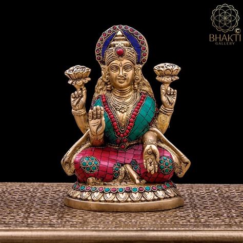 A Small Statue Sitting On Top Of A Wooden Table Next To A Black