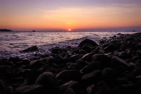 Black Rocks on Beach during Sunset · Free Stock Photo