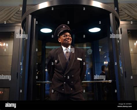 A Smiling Hotel Doorman Waits For Patrons Stock Photo Alamy