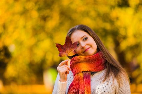 Premium Photo Smiling Woman Holding Maple Leaf Outdoors