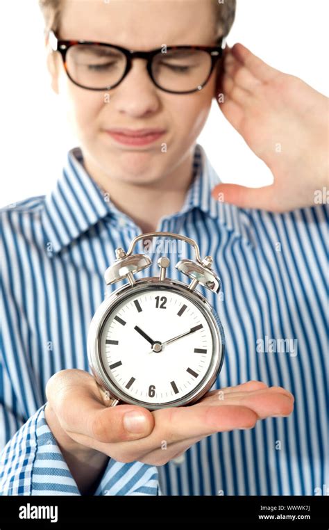 Boy Irritated With Noise Of Alarm Clock Isolated Over White Stock Photo