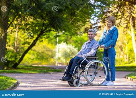 Homme En Fauteuil Roulant Se Promener Dans Le Parc Avec Sa Femme Image