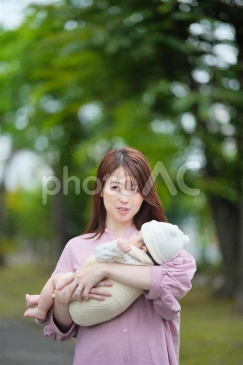 公園の木々の前で赤ちゃんを抱っこしているお母さん No 25510918｜写真素材なら「写真ac」無料（フリー）ダウンロードok