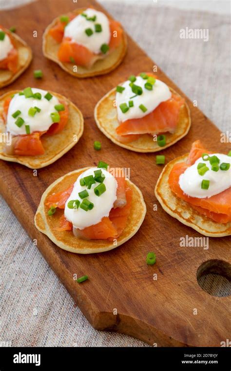 Homemade Blini With Smoked Salmon Creme And Chives On A Rustic Wooden