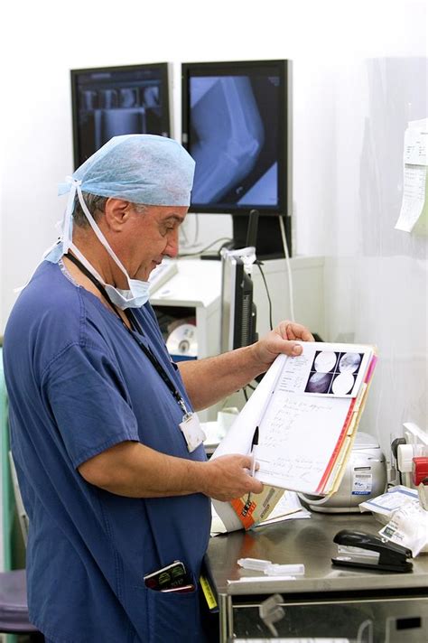 Surgeon Reading A Patients Notes Photograph By Mark Thomas Science