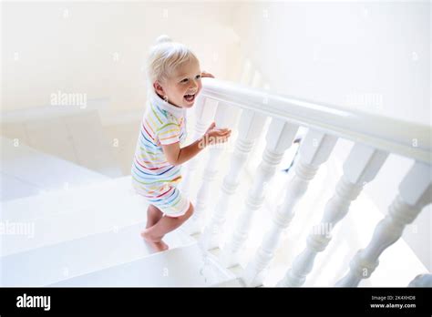 Kid Walking Stairs In White House Baby Boy Playing In Sunny Staircase