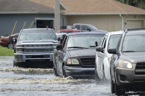 Hurricane Flooded Street With Moving Cars And Surrounded With Water