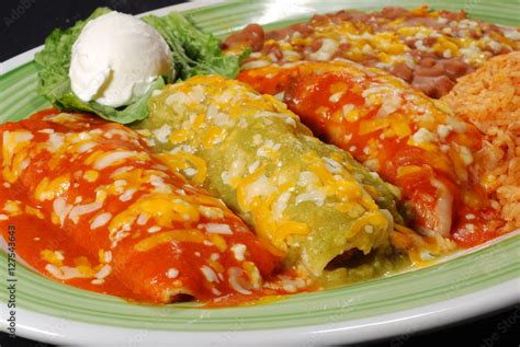 Tres Enchiladas En Salsa Roja Y Verde Con Crema Agria Arroz Frijoles Y