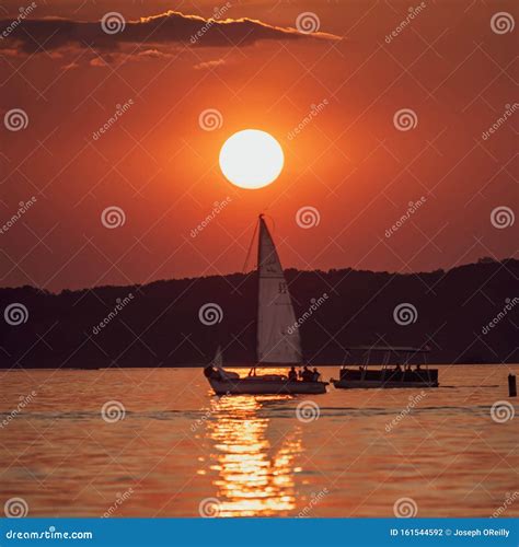 Sailboat & Pontoon Boat at Sunset Stock Photo - Image of sunset, sailboat: 161544592