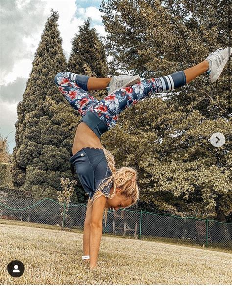 A Woman Doing A Handstand In The Grass