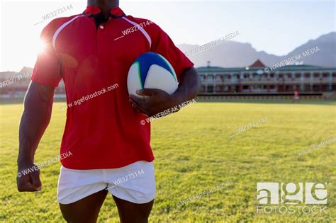 Male Rugby Player Holding Rugby Ball In The Ground Stock Photo