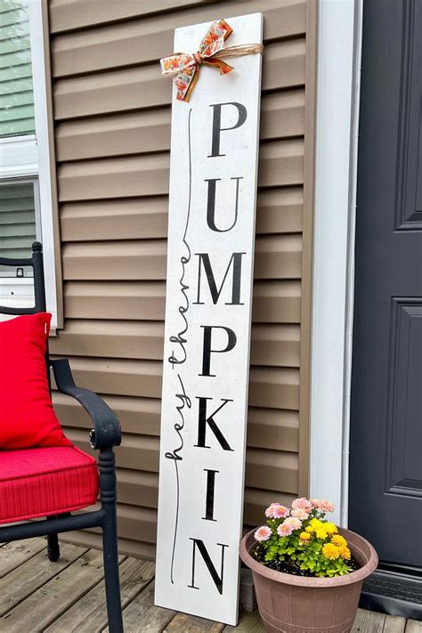 A Wooden Sign That Says Pumpkin Next To A Potted Plant On The Front Porch