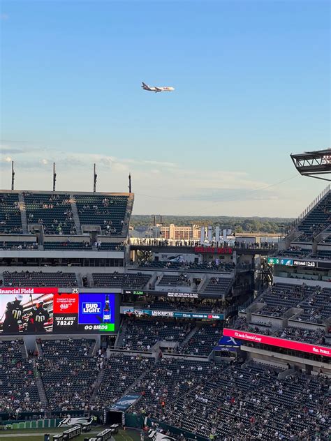 Airplane Flying in the Sky Over Stadium · Free Stock Photo