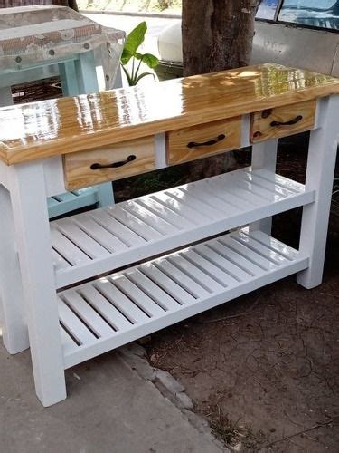 A White Table With Two Drawers On It And A Potted Tree In The Background