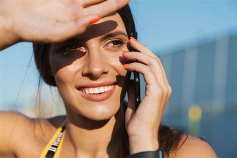 Imagen de mujer alegre en ropa deportiva hablando por teléfono celular